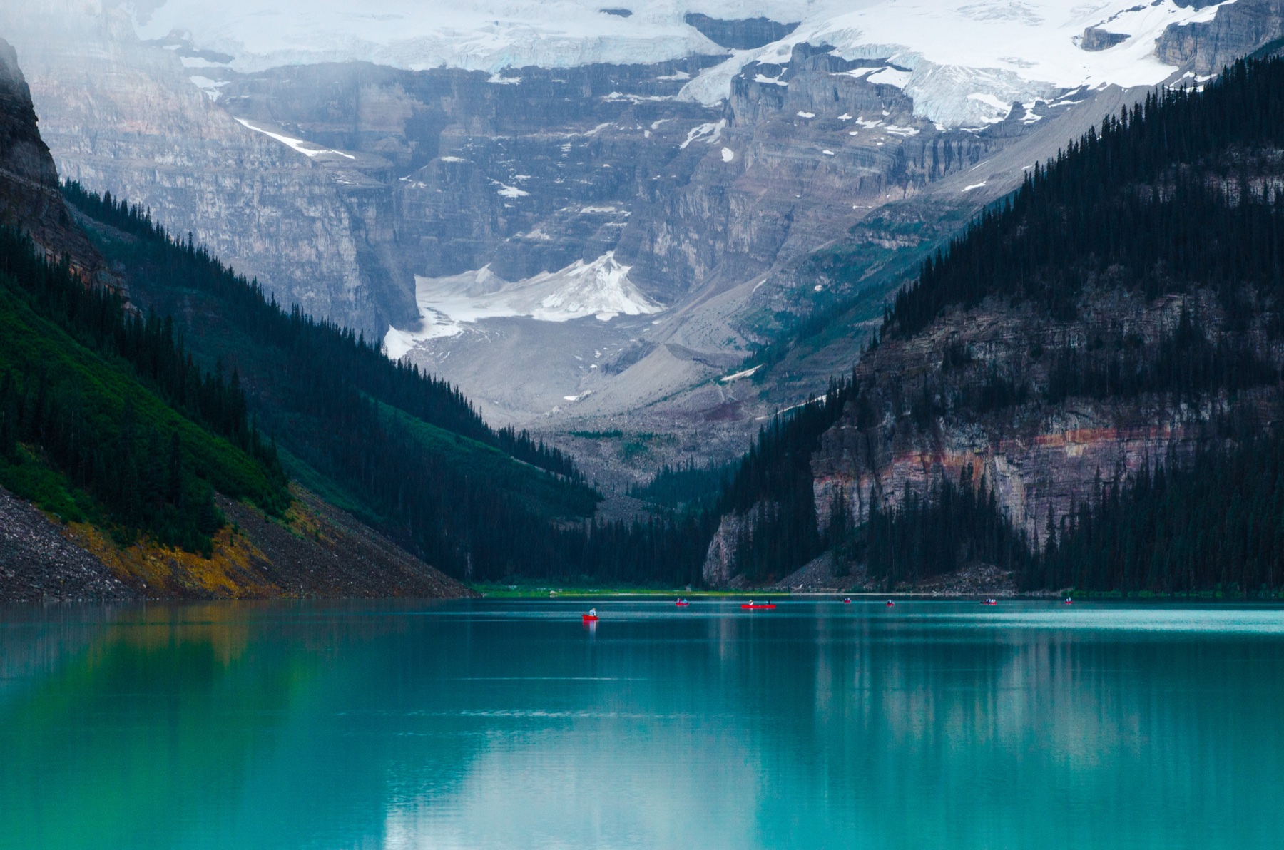 Turquoise alpine lake beneath a snow-covered mountain