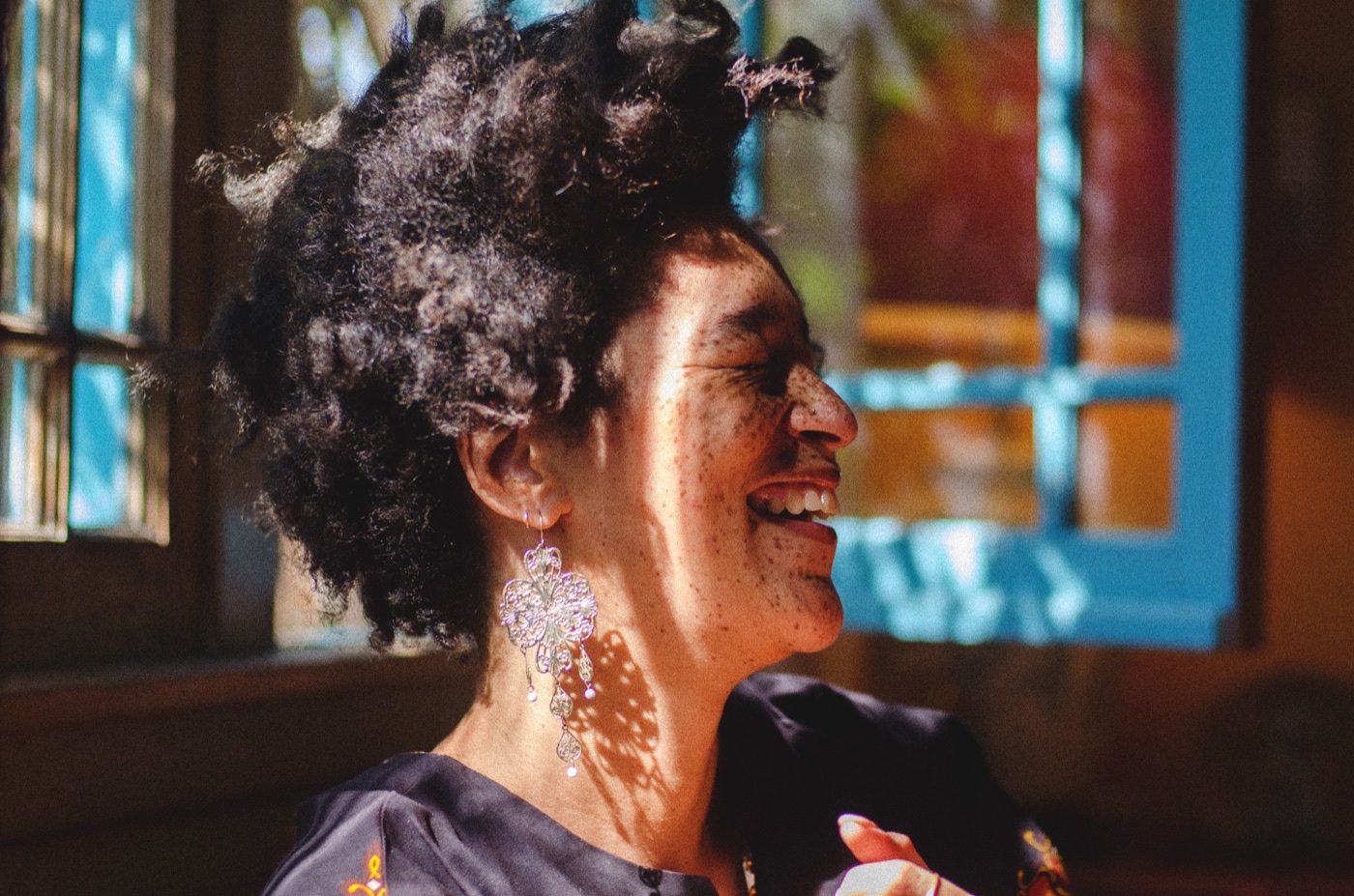 Woman smiling in patterned window light